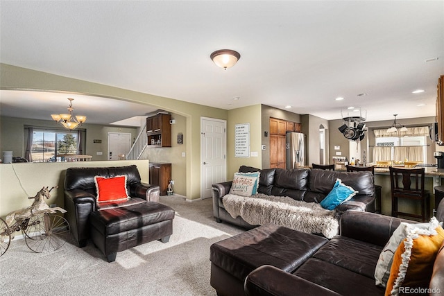 living room with an inviting chandelier, recessed lighting, arched walkways, and light carpet