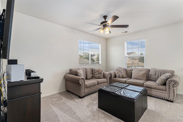 living area with a ceiling fan, visible vents, light colored carpet, and baseboards