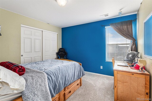 bedroom featuring baseboards, a closet, carpet floors, and visible vents