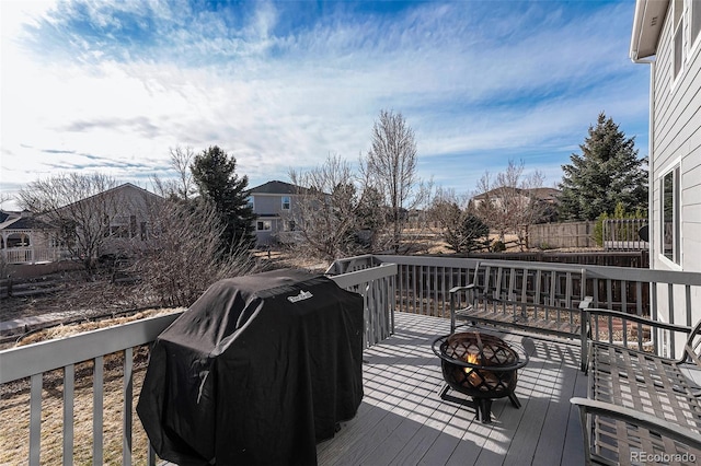 deck with grilling area and a fire pit