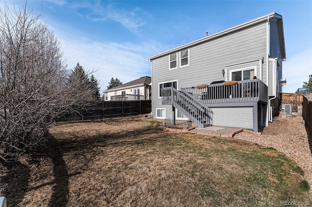 rear view of house with stairs, a fenced backyard, a lawn, and a wooden deck