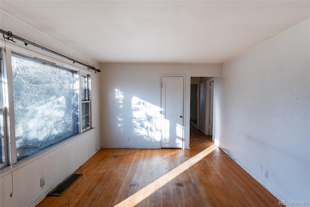 unfurnished room with hardwood / wood-style flooring