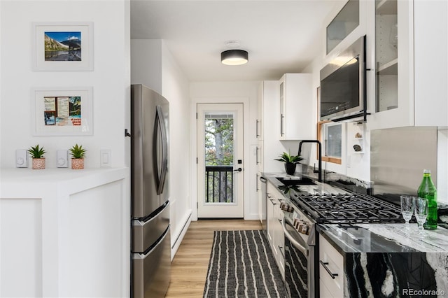 236 Harris Dr, Idaho Springs, CO 80452 - kitchen featuring stainless steel appliances, a sink, white cabinets, light wood-type flooring, and glass insert cabinets