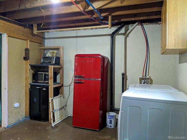 unfinished basement featuring washer / dryer and freestanding refrigerator