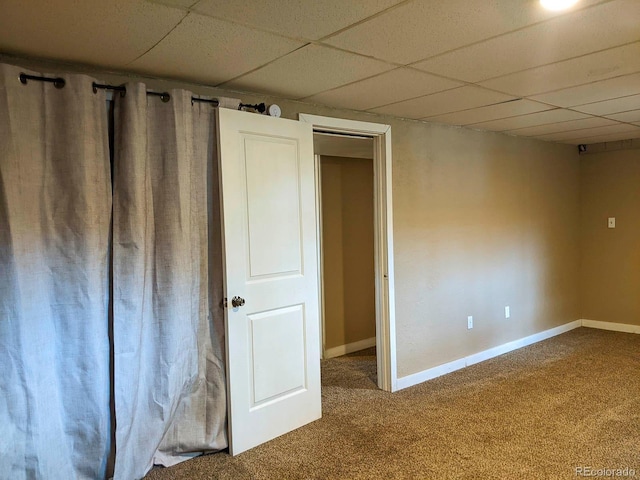 unfurnished bedroom with carpet flooring, a paneled ceiling, and baseboards