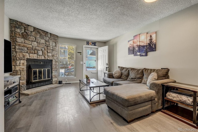 3618 Queen Anne Way, Colorado Springs, CO 80917 - living room featuring a stone fireplace, a textured ceiling, and wood finished floors