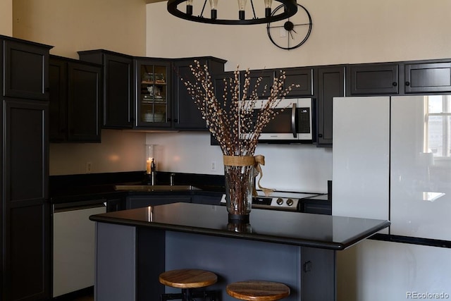 kitchen with a kitchen breakfast bar, a center island, sink, and white refrigerator