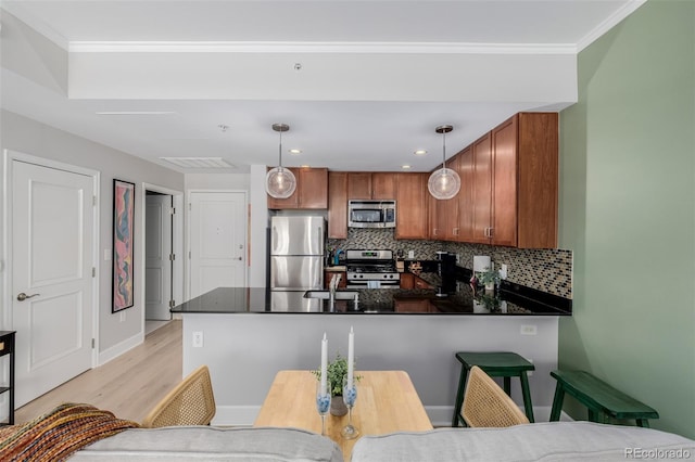 1975 N Grant St Unit 509, Denver, CO 80203 - kitchen featuring stainless steel appliances, dark countertops, a peninsula, brown cabinets, and crown molding