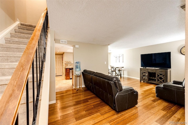 living room featuring wood-type flooring and a textured ceiling