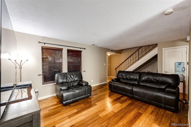 living room featuring wood-type flooring and a textured ceiling