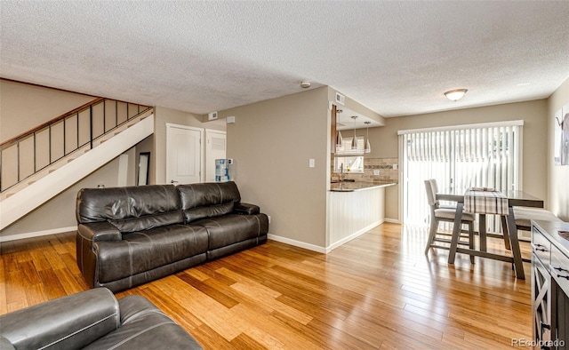 living room with a textured ceiling and light hardwood / wood-style floors