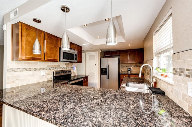 kitchen featuring kitchen peninsula, decorative light fixtures, and appliances with stainless steel finishes