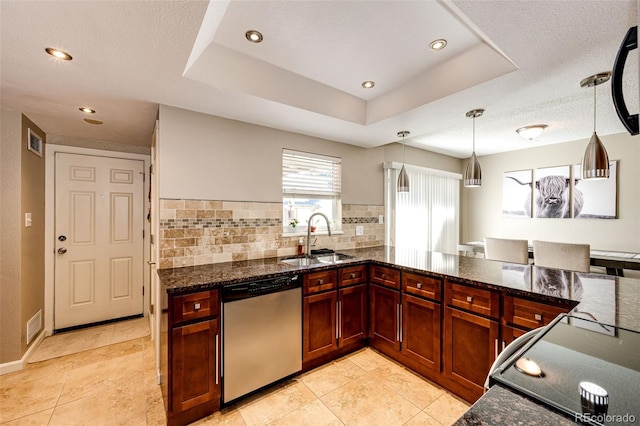 kitchen with pendant lighting, a raised ceiling, sink, stainless steel dishwasher, and decorative backsplash