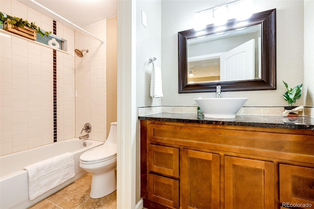 full bathroom featuring vanity, tiled shower / bath combo, and toilet