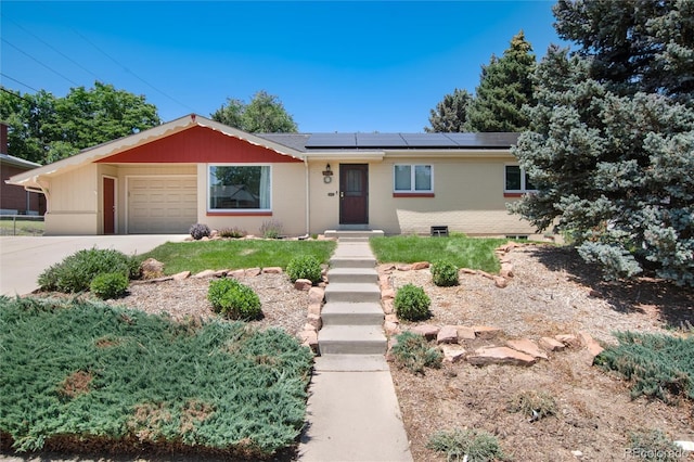 5067 S Mabre Ct, Littleton, CO 80123 - ranch-style home featuring concrete driveway, roof mounted solar panels, an attached garage, and brick siding