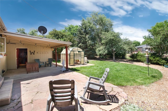 5067 S Mabre Ct, Littleton, CO 80123 - view of patio / terrace featuring a greenhouse and an outbuilding