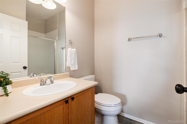 7408 S Alkire St Unit 301, Littleton, CO 80127 - bathroom featuring toilet, a shower with door, vanity, and baseboards