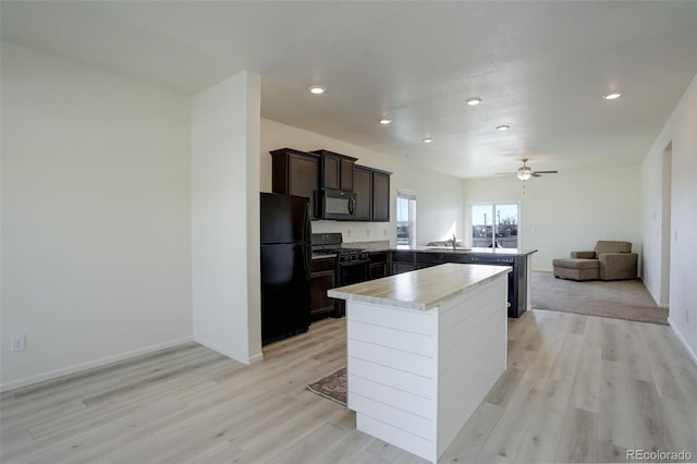 kitchen featuring black appliances, ceiling fan, sink, and light hardwood / wood-style flooring