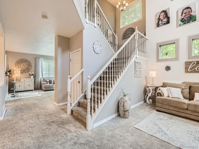 8010 Raspberry Dr, Frederick, CO 80504 - carpeted living area featuring stairway, a chandelier, a high ceiling, and baseboards