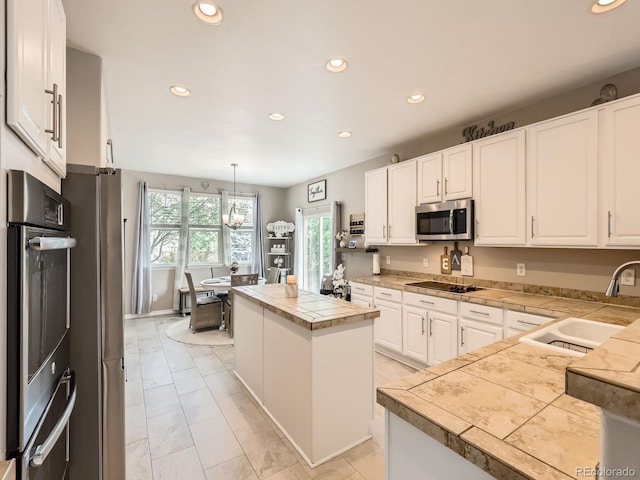 8010 Raspberry Dr, Frederick, CO 80504 - kitchen featuring appliances with stainless steel finishes, a sink, recessed lighting, white cabinets, and a center island