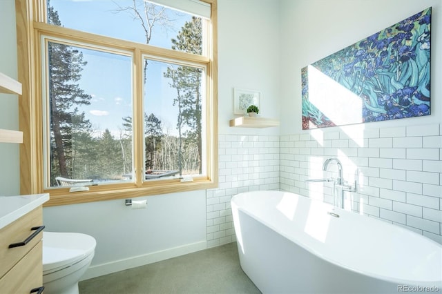 bathroom featuring a bathing tub, vanity, and toilet