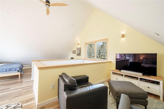 living room featuring ceiling fan, lofted ceiling, and light hardwood / wood-style flooring