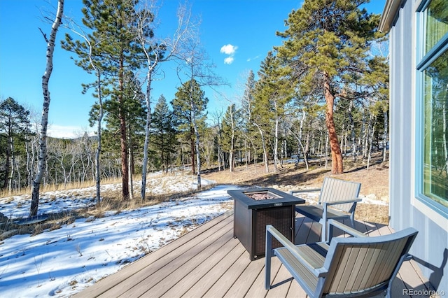 snow covered deck featuring a fire pit