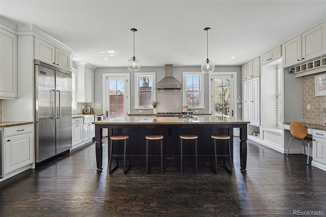 201 S Lafayette St, Denver, CO 80209 - kitchen featuring stainless steel built in fridge, wall chimney range hood, a breakfast bar area, backsplash, and recessed lighting