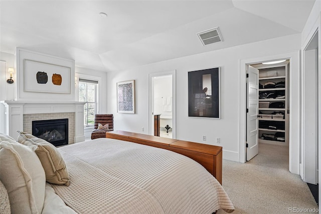 201 S Lafayette St, Denver, CO 80209 - bedroom with light carpet, a walk in closet, vaulted ceiling, a glass covered fireplace, and ensuite bathroom