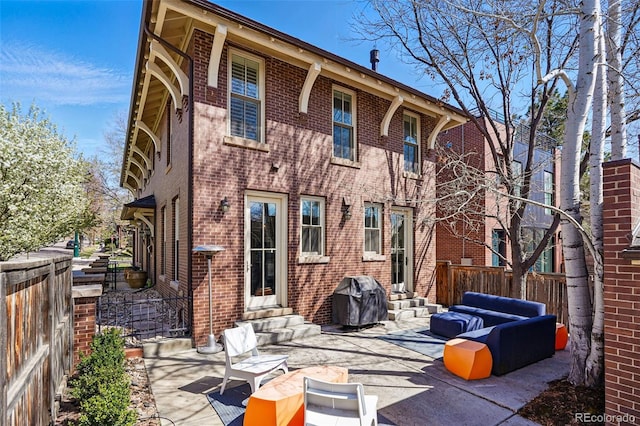 201 S Lafayette St, Denver, CO 80209 - back of property with entry steps, an outdoor living space, brick siding, a fenced backyard, and a patio area