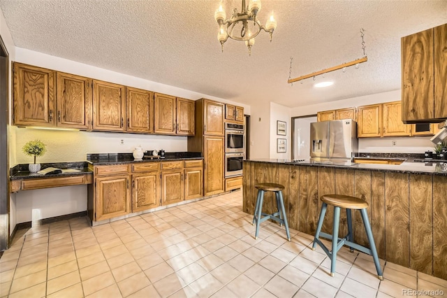 kitchen with stainless steel appliances, brown cabinets, and built in study area