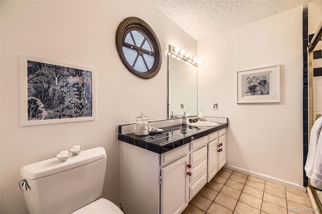 full bath featuring a textured ceiling, vanity, tile patterned flooring, and toilet