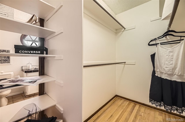 walk in closet with light wood-style floors