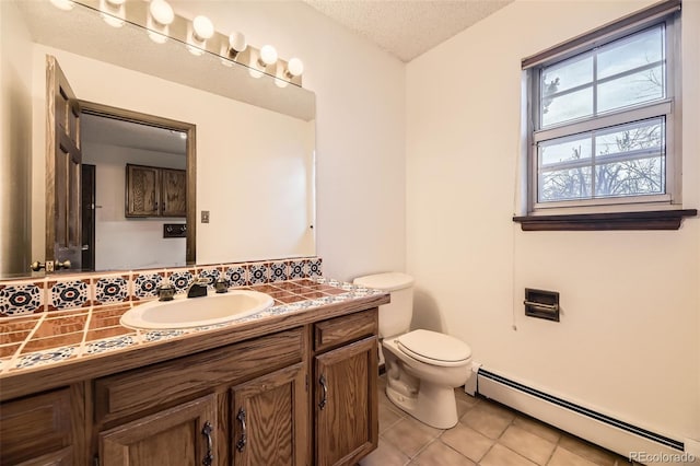 bathroom featuring toilet, tile patterned floors, a textured ceiling, vanity, and a baseboard heating unit