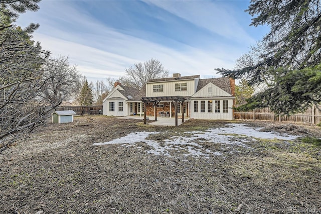 back of property featuring an outdoor structure, a fenced backyard, a patio, and a storage shed