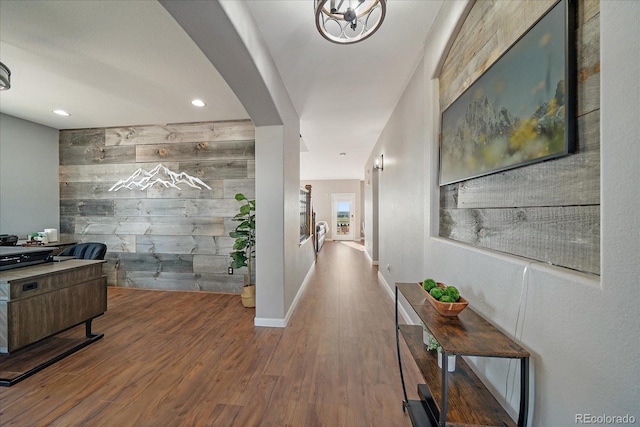 12420 Verbena St, Thornton, CO 80602 - hall featuring wooden walls, an accent wall, wood finished floors, recessed lighting, and arched walkways