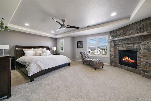 12420 Verbena St, Thornton, CO 80602 - carpeted bedroom with a raised ceiling, recessed lighting, a stone fireplace, and a ceiling fan