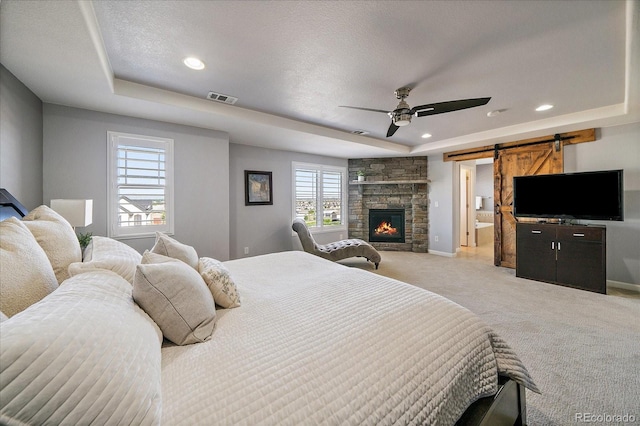 12420 Verbena St, Thornton, CO 80602 - bedroom with a tray ceiling, light colored carpet, a barn door, recessed lighting, and ceiling fan