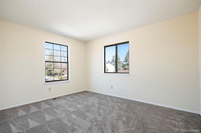 carpeted spare room with a textured ceiling