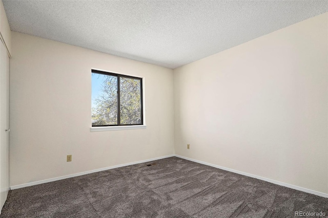 carpeted spare room with a textured ceiling