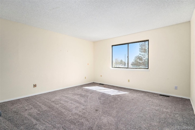 carpeted empty room with a textured ceiling