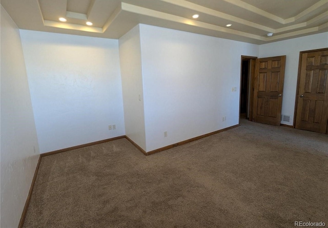 empty room with visible vents, carpet floors, baseboards, a tray ceiling, and recessed lighting