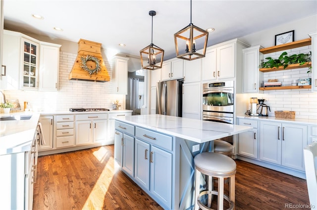 kitchen featuring white cabinets, appliances with stainless steel finishes, and premium range hood