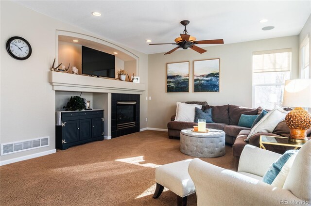 living room with ceiling fan, a fireplace, and carpet