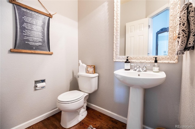 bathroom with wood-type flooring and toilet