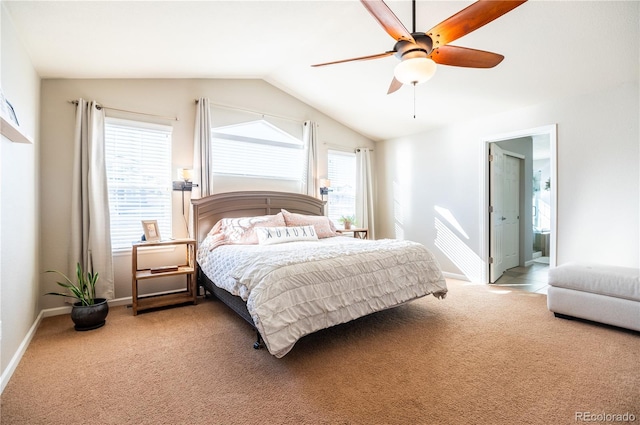 carpeted bedroom featuring multiple windows, vaulted ceiling, ceiling fan, and ensuite bath