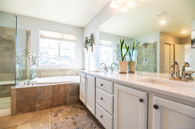 bathroom with vanity and shower with separate bathtub