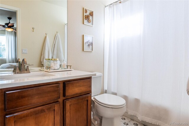 full bathroom with ceiling fan, vanity, toilet, and shower / tub combo with curtain