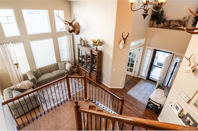 entryway featuring hardwood / wood-style floors, a notable chandelier, and a high ceiling