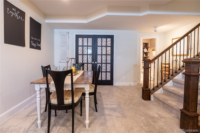 dining space featuring light colored carpet and french doors